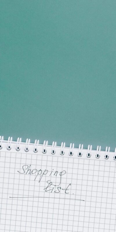 A top-down view of a shopping cart, list, card, and bag on a green background.